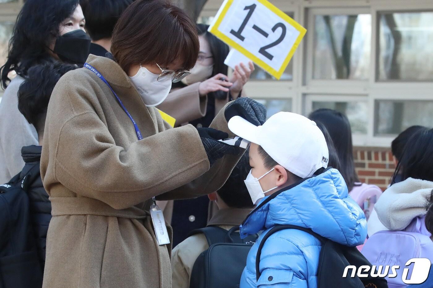 한 초등학교에서 담임 교사가 1학년 교실로 들어가기 전 신입생들의 체온을 측정하고 있다. 2022.3.2/뉴스1 ⓒ News1 공정식 기자