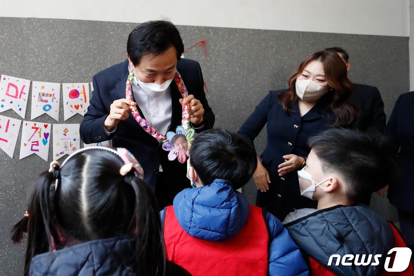 본문 이미지 - 오세훈 서울시장이 서울 강서구 마곡단지 내 서울형 모아어린이집에서 현장 간담회에 앞서 아이들에게 목걸이를 선물 받고 있다. 2022.3.22/뉴스1 ⓒ News1 이승배 기자