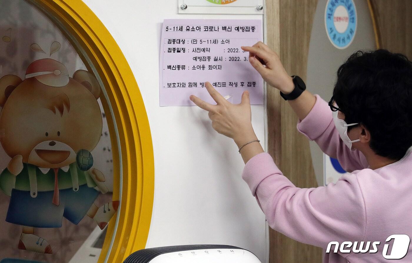 본문 이미지 - 서울 시내 한 소아청소년과의원 관계자가 소아 대상 코로나19 백신 접종 사전예약 안내문을 붙이는 모습. 2022.3.24/뉴스1 ⓒ News1 김진환 기자