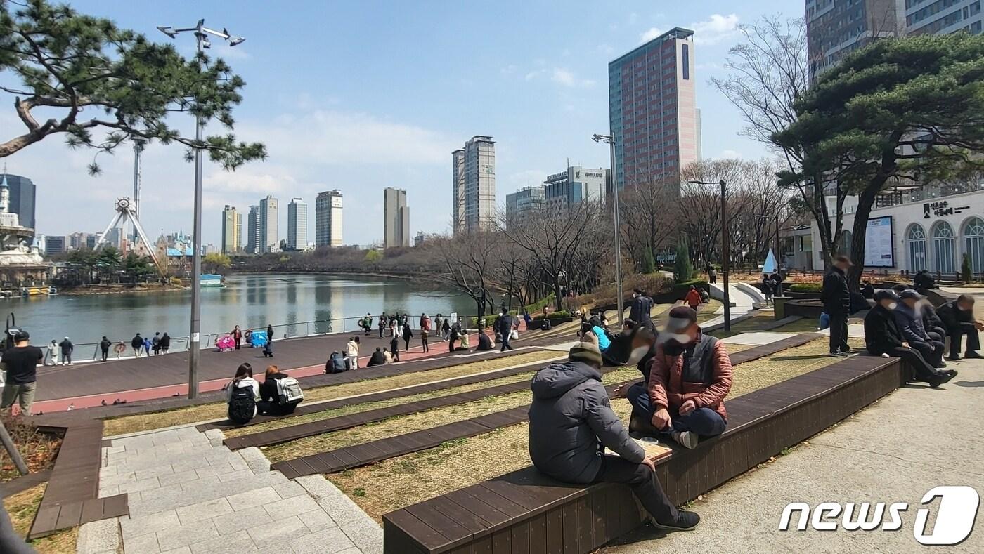 본문 이미지 - 27일 낮 서울 송파구 석촌호수 둘레길 수변무대 인근에서 시민들이 나들이를 즐기고 있다. ⓒ 뉴스1 김진 기자