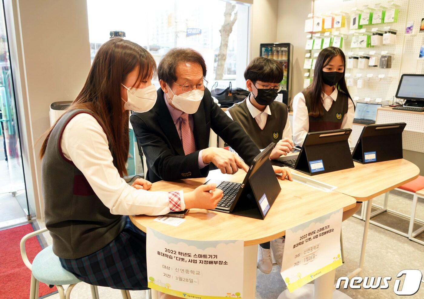 조희연 서울시교육감이 스마트기기 휴대 학습 &#39;디벗&#39; 배부 현장인 서울 서대문구 KT플라자 가좌역점에서 신연중학교 1학년 학생들과 유해정보필터링 앱, FocusBuddy, 뉴쌤 웹사이트 등 사전 설치된 앱을 확인하며 지난해 3월 시연해보고 있다. &#40;서울시교육청 제공&#41;/뉴스1