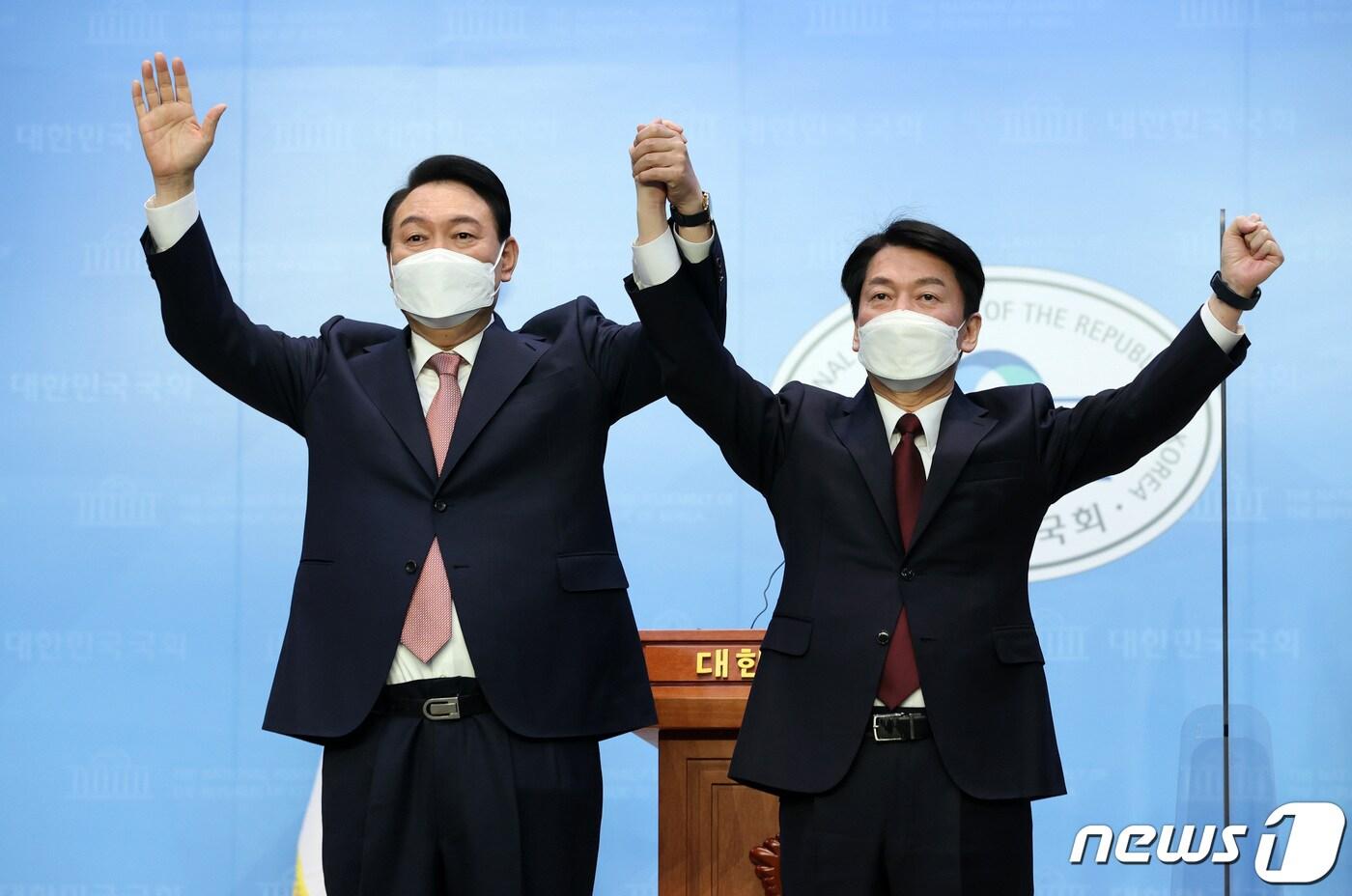 윤석열 국민의힘 대선 후보와 안철수 국민의당 대선 후보가 3일 오전 서울 여의도 국회 소통관에서 단일화 기자회견을 마친 뒤 손을 맞잡고 있다. 2022.3.3/뉴스1 ⓒ News1 구윤성 기자