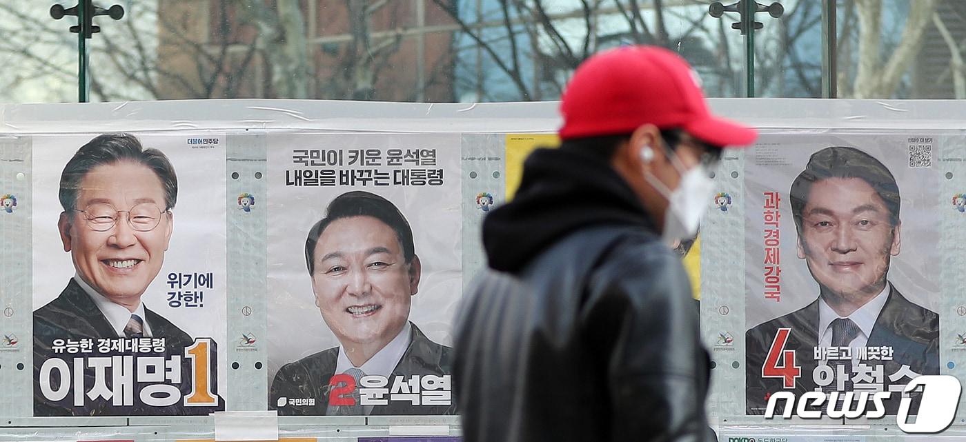 본문 이미지 - 제20대 대통령 선거 사전투표를 하루 앞둔 3일 오후 서울 종각옆 앞에서 유권자들이 후보들의 선거벽보 앞을 지나고 있다. 윤석열 국민의힘 대선 후보와 안철수 국민의당 대선 후보는 이날 오전 "더 좋은 대한민국을 만드는 시작으로서의 정권교체, 즉 '더 좋은 정권교체'를 위해 뜻을 모으기로 했다＂고 밝혔다. 2022.3.3/뉴스1 ⓒ News1 김진환 기자