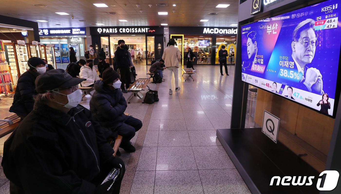 제20대 대통령 선거 투표일인 9일 오후 서울 중구 서울역에서 유권자들이 방송3사 출구조사 결과를 지켜보고 있다. 2022.3.9/뉴스1 ⓒ News1 김진환 기자