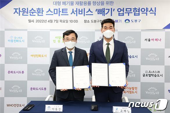 본문 이미지 - 이동진 도봉구청장(왼쪽)과 고재성 ㈜같다 대표이사가 7일 대형폐기물 간편 배출 시스템 '빼기' 도입을 위한 업무협약을 체결하고 있다(도봉구 제공).2022.4.11/ⓒ 뉴스1