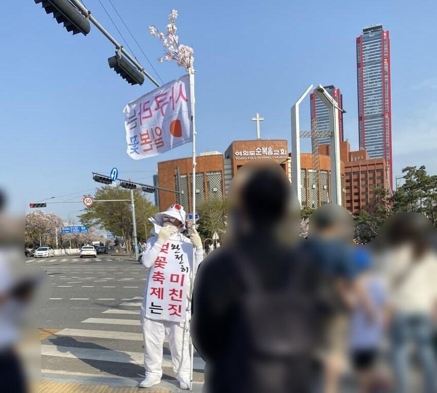 본문 이미지 - 지난 10일 서울 여의도 윤중서로 인근에 나타난 1인 시위 남성. (온라인 커뮤니티 갈무리) ⓒ 뉴스1