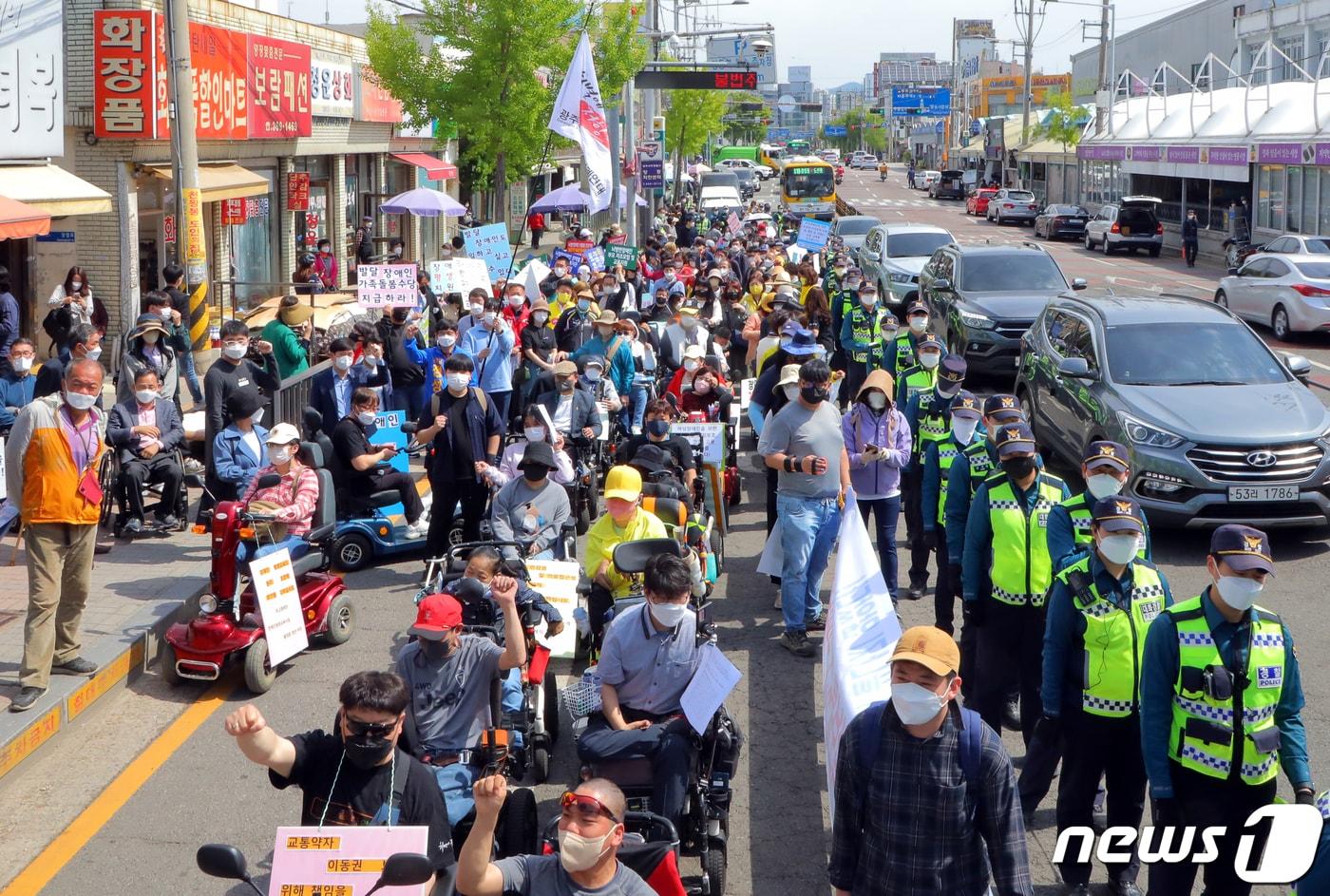 본문 이미지 - 광주장애인차별철폐연대와 공동투쟁단이 지난해 4월18일 오전 광주 서구 양동시장 앞에서 가진 결의대회에서 휠체어 리프트 철거와 엘리베이터 설치를 요구하며 행진하고 있다. 2022.4.18/뉴스1 ⓒ News1 이수민 기자