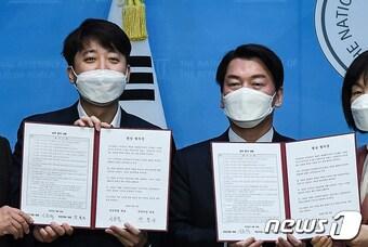 본문 이미지 - 이준석 국민의힘 대표와 안철수 국민의당 대표가 18일 서울 여의도 국회 소통관에서 합당 합의문을 들어보이고 있다. (공동취재) 2022.4.18/뉴스1 ⓒ News1 유승관 기자