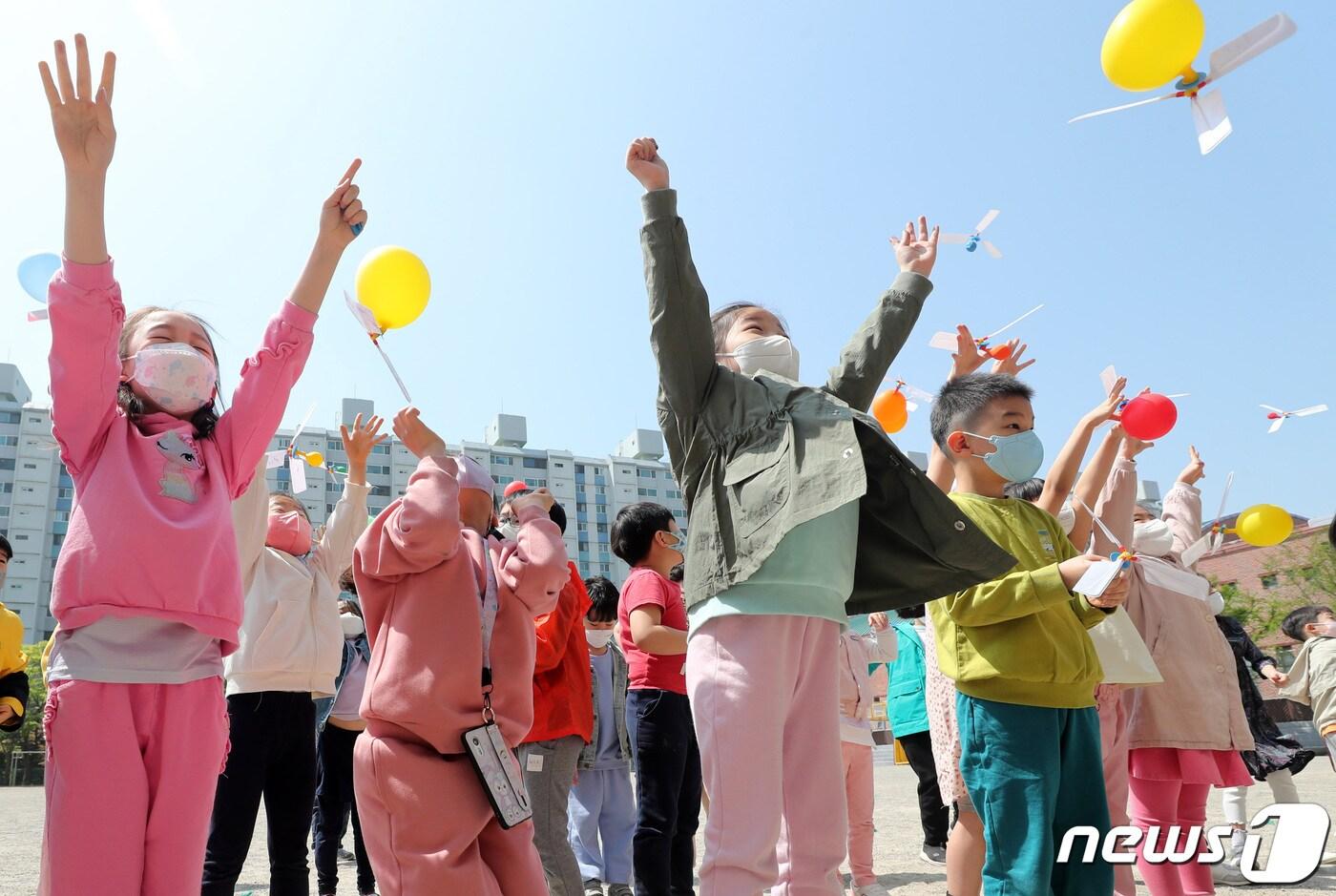 본문 이미지 - 과학의 날을 하루 앞둔 20일 오전 경기 수원 영통구 효원초등학교에서 1학년 학생들이 풍선 헬리콥터를 날리고 있다. (공동취재) 2022.4.20/뉴스1 ⓒ News1 김영운 기자