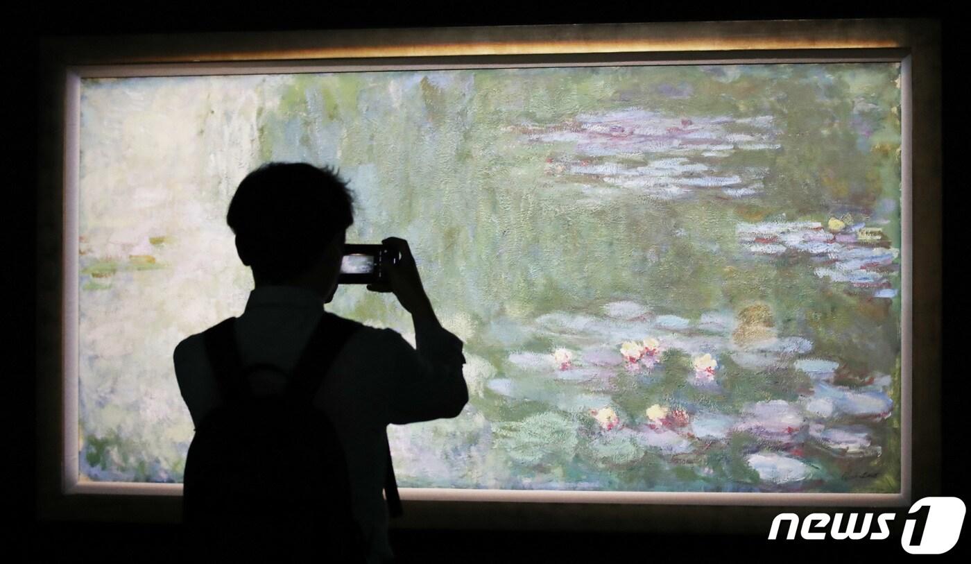 27일 오전 서울 용산구 국립중앙박물관에서 열린 ‘어느 수집가의 초대 - 고 이건희 회장 기증 1주년 기념전’ 언론공개회에서 참석자들이 모네의 '수련이 있는 연못'을 관람하고 있다.ⓒ News1 박지혜 기자