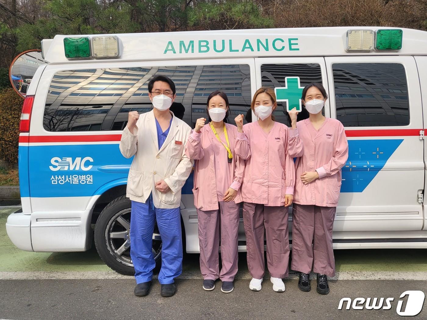 본문 이미지 - 삼성서울병원 에크모 개발 총괄을 맡은 조양현 삼성서울병원 심장외과 교수(왼쪽)와 에크모 이송팀이 앰뷸런스 앞에서 에크모 이송팀과 함께 포즈를 취하고 있다.ⓒ 뉴스1