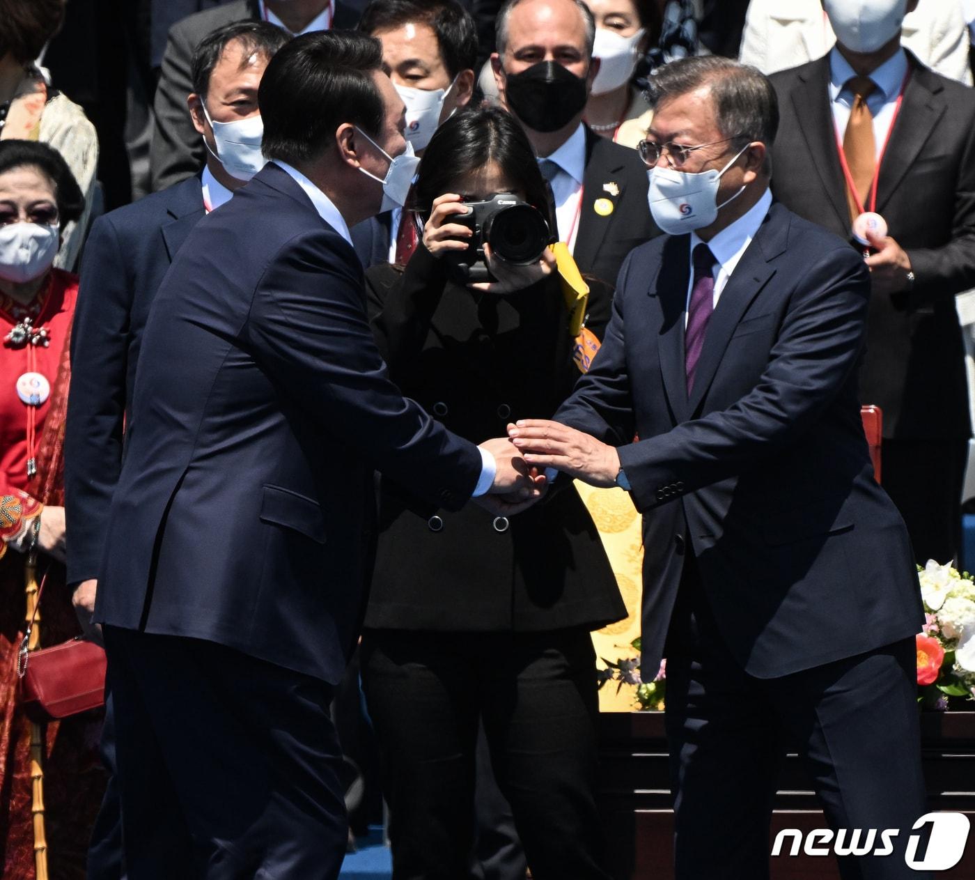 본문 이미지 - 윤석열 대통령이 2022년 5월 10일 오전 서울 여의도 국회에서 열린 제20대 대통령 취임식에서 문재인 전 대통령과 인사하고 있다. 2022.5.10/뉴스1 ⓒ News1 국회사진취재단