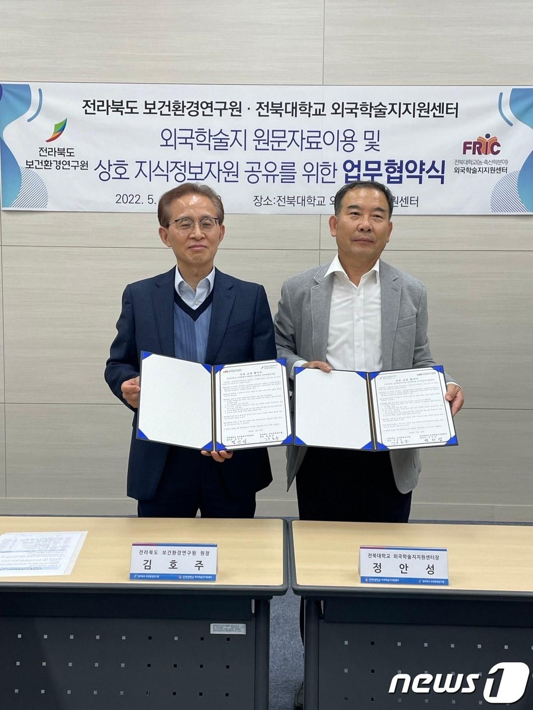 본문 이미지 - 12일 김호주 전북도 보건환경연구원장(왼쪽)과 정안성 전북대 외국학술지지원센터장이 상호 자료 공동활용 업무협약을 체결하고 기념 촬영을 하고 있다.(전북도 제공)2022.5.12/ⓒ 뉴스1