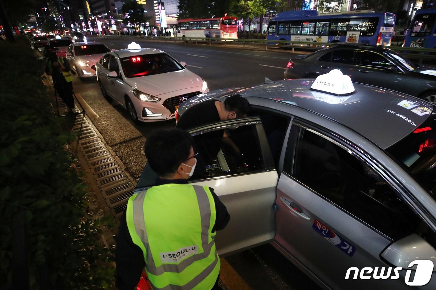 본문 이미지 - 12일 밤 서울 서초구 강남역 인근에서 승차지원단이 택시 임시승차대를 설치하고 시민들의 택시 탑승을 돕고 있다.2022.5.12/뉴스1 ⓒ News1 이광호 기자