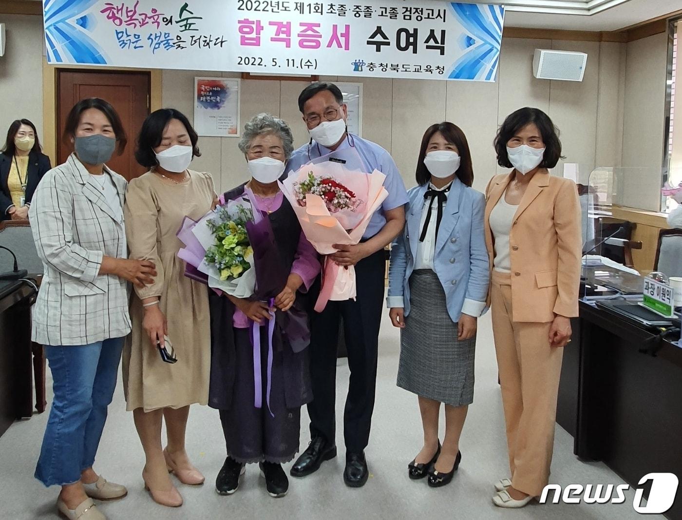 본문 이미지 - 충북 충주에 사는 김정혜씨가 중졸 검정고시 합격증서를 받고 가족의 축하를 받고 있다.(평생열린학교 제공)2022.5.13/ⓒ 뉴스1