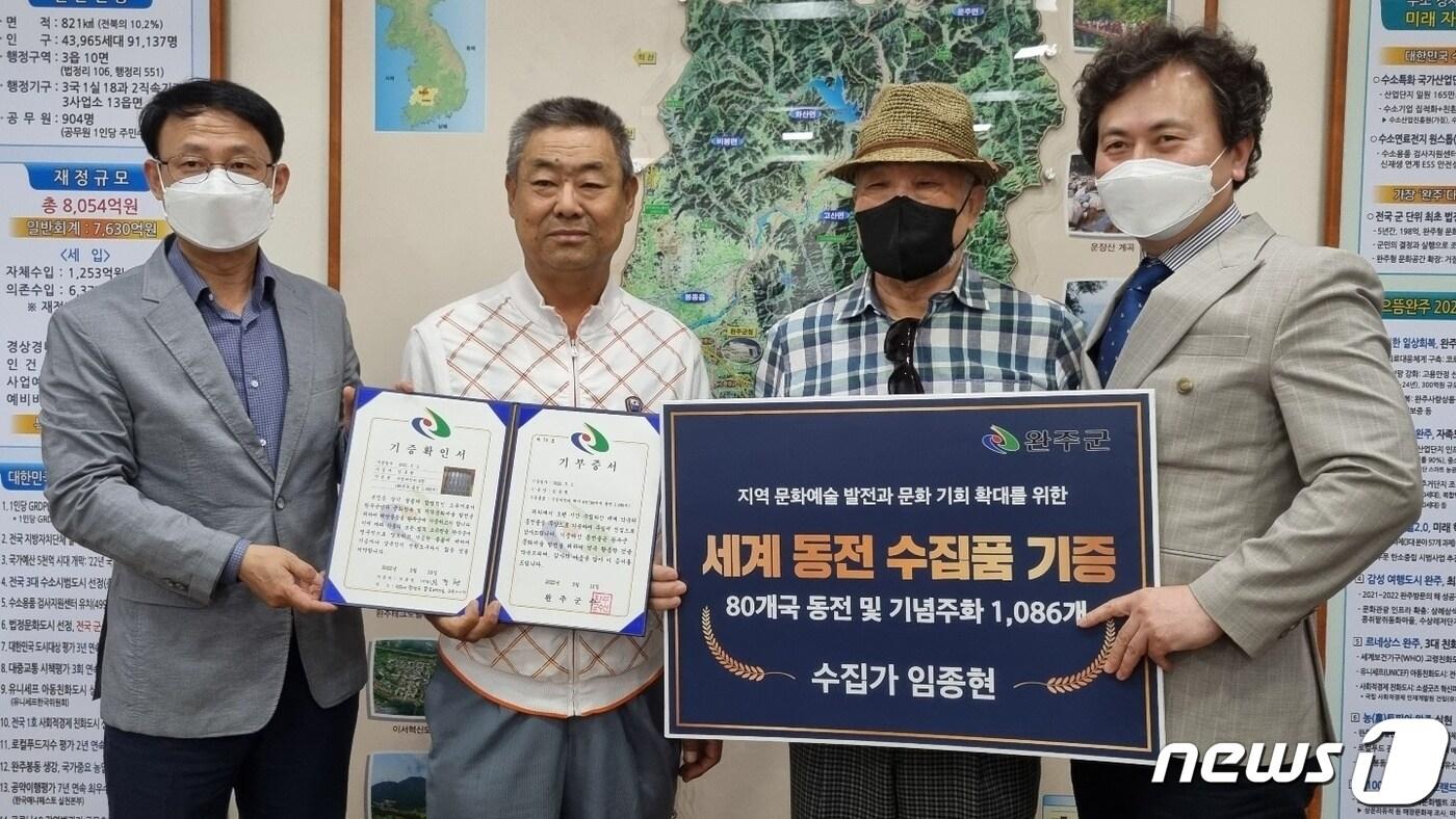 본문 이미지 - 전북 완주군은 동전수집가 임종현씨가 지난 16일 완주군청을 찾아 동전 1086개(80국가)가 담긴 책자 6권을 전달했다고 17일 밝혔다.(왼쪽부터 신국섭 군 행정복지국장, 임종현씨, 임씨 지인 박헌용씨, 김성명 부군수. 완주군 제공)2022.5.17/ⓒ 뉴스1