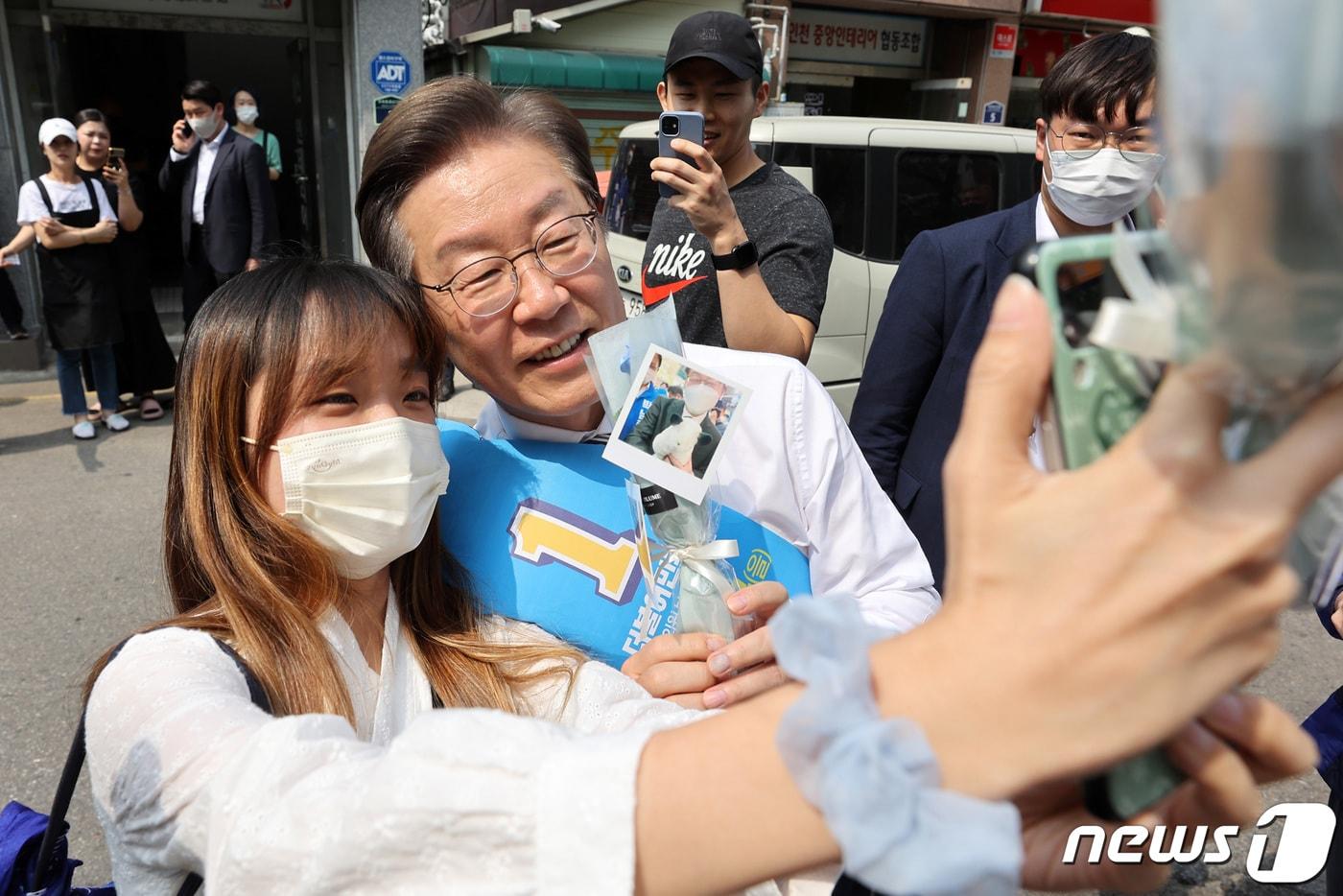 본문 이미지 - 이재명 더불어민주당 총괄선거대책위원장이 20일 인천 계양구 계산3동 일대에서 시민들과 인사를 나누던 중 한 지지자의 사진 요청에 응하고 있다. 2022.5.20/뉴스1 ⓒ News1 조태형 기자