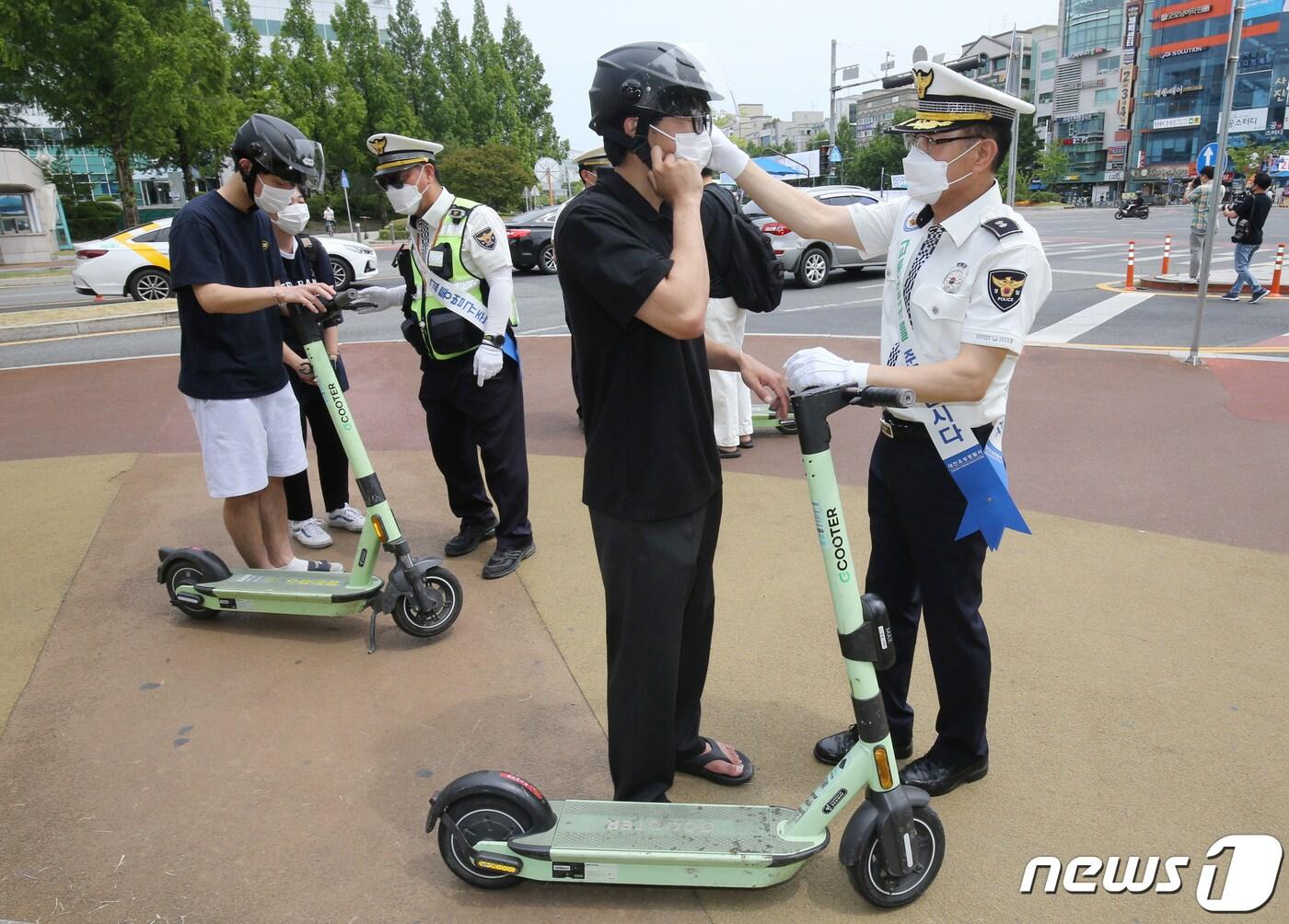 본문 이미지 - 최근 전동퀵보드 관련 사고가 늘어가고 있는 가운데 25일 대전 유성구 충남대학교 앞에서 유성경찰서 소속 경찰관들이 전동킥보드 헬멧 착용 캠페인을 하고 있다. 2022.5.25/뉴스1 ⓒ News1 김기태 기자