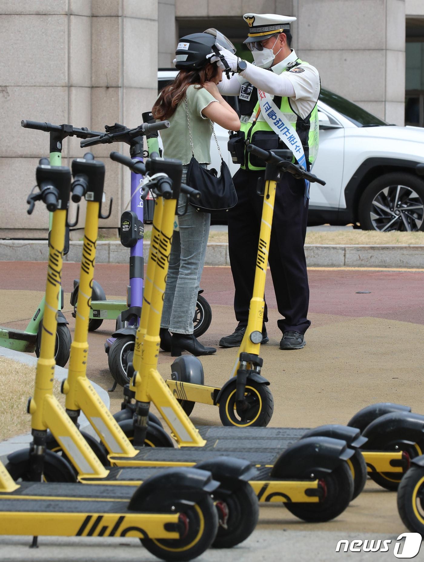 본문 이미지 - 전동퀵보드 헬멧 착용 캠페인을 하고 있는 경찰 ⓒ News1 김기태 기자