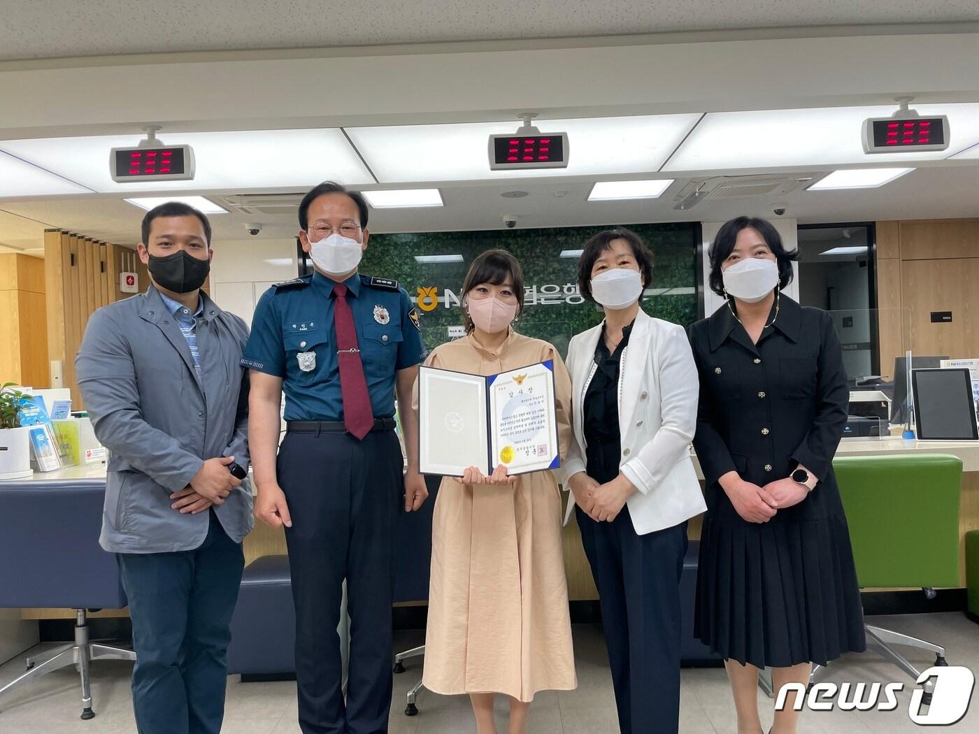 본문 이미지 - 강원 원주경찰서가 26일 NH농협은행 원주 원일로지점에서 최근 보이스피싱 피해를 예방한 안효미 원일로지점 계장(가운데)에게 감사장을 전달한 가운데 관계자들이 함께 기념사진을 촬영하고 있다. (원주경찰서 제공) 2022.5.26/뉴스1