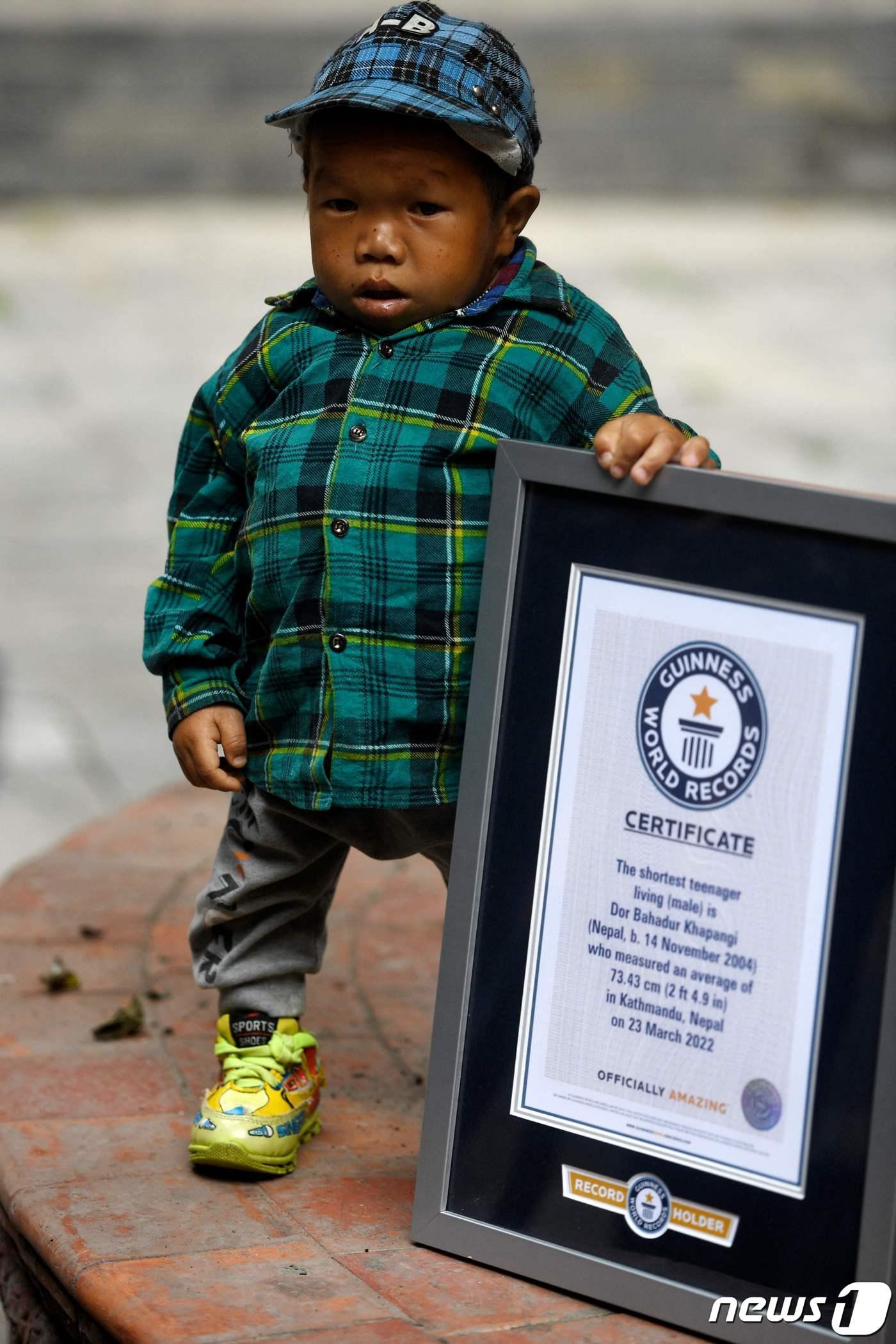 본문 이미지 - 24일(현지시간) 네팔 카트만두에서 도르 바하두르 카판지가 기네스 세계 기록 인증서를 옆에 두고 포즈를 취하고 있다 ⓒ AFP=뉴스1