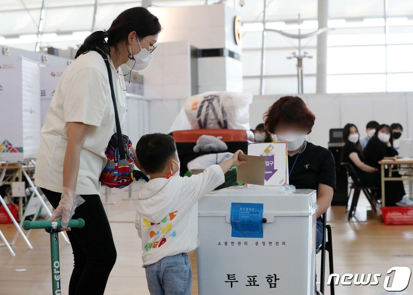 본문 이미지 - 6.1동시지방선거 사전투표일인 27일 인천국제공항에 설치된 사전투표소에서 한 유권자가 아이와 함께 투표를 하고 있다. 2022.5.27/뉴스1 ⓒ News1 박세연 기자