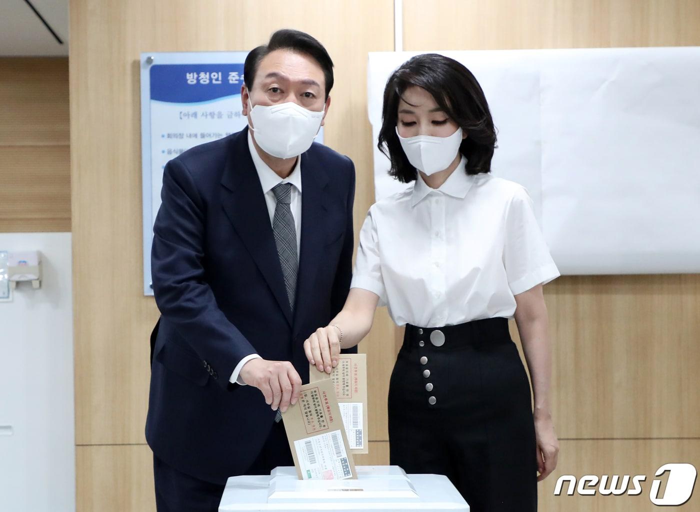 본문 이미지 - 윤석열 대통령과 부인 김건희 여사가 27일 용산구의회에 마련된 제8회 전국동시지방선거·국회의원 보궐선거 사전투표소에서 한 표를 행사하고 있다. (대통령실사진기자단) 2022.5.27/뉴스1 ⓒ News1 오대일 기자