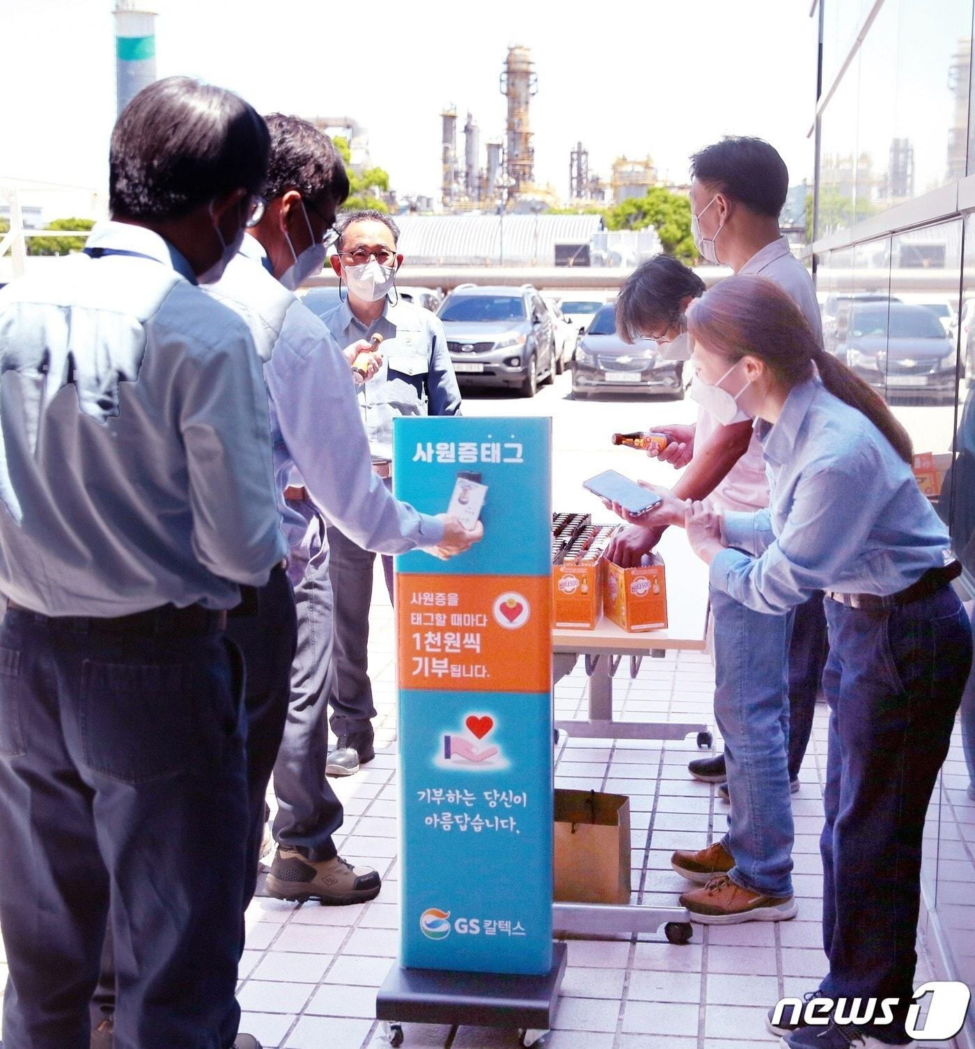 본문 이미지 - 이두희 GS칼텍스 생산본부장을 비롯한 여수공장 임직원들이 27일 구내식당 출구에 비치된 '소액기부 시스템'에 사원증을 태그하며 기부에 동참하고 있다.(GS칼텍스 제공)2022.5.27/뉴스1