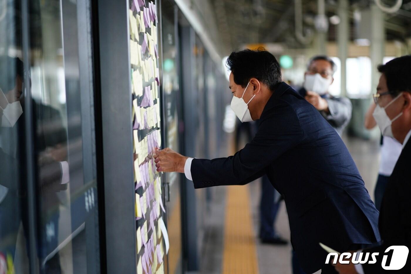 오세훈 국민의힘 서울시장 후보가 28일 오전 서울 광진구 구의역에서 희생자를 추모하는 메모를 붙이고 있다. (오세훈 서울시장 후보 측 제공) 2022.5.28/뉴스1