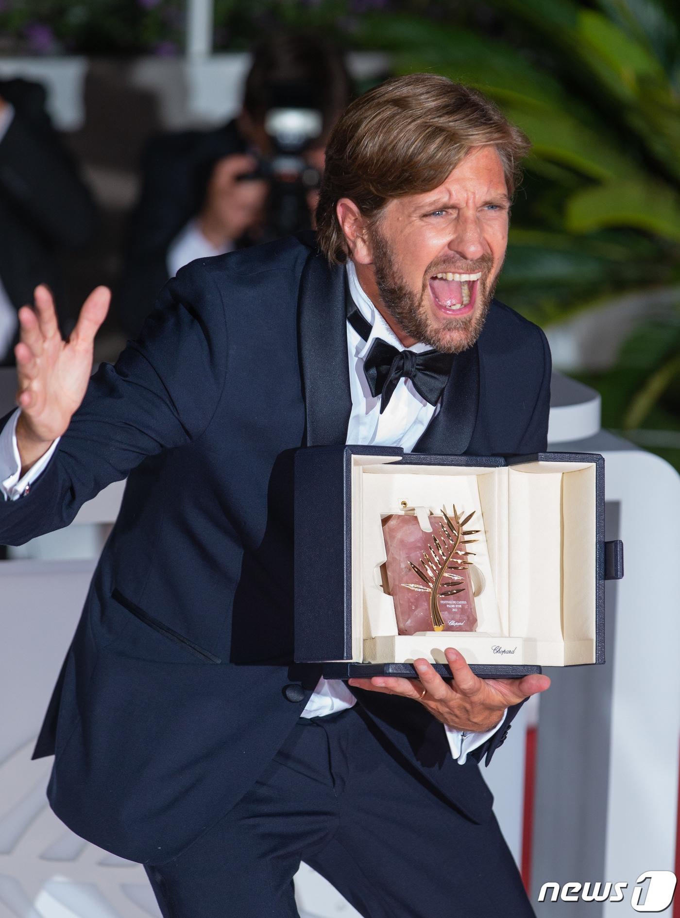 본문 이미지 - 제75회 칸 국제영화제 폐막일인 28일(현지시간) 프랑스 남부 칸 ‘팔레 데 페스티벌’(Palais des Festivals)에서 ’슬픔의 삼각형'(TRIANGLE OF SADNESS)으로 황금 종려상을 거머쥔 루벤 외스틀룬드 감독이 환호하고 있다. 2022.5.29/뉴스1 ⓒ News1 이준성 기자