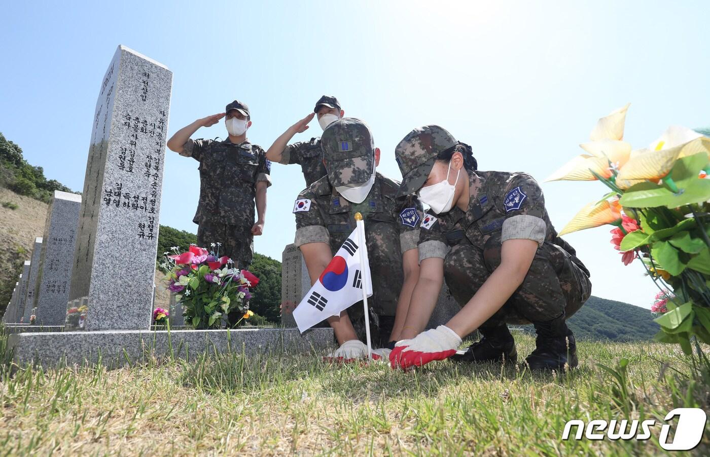본문 이미지 - 호국보훈의 달을 하루 앞둔 31일 오후 대구 영진전문대 공군 부사관학군단이 경북 영천시 고경면 국립영천호국원을 찾아 호국영령이 잠든 묘역에 태극기를 꽂고 있다. 2022.5.31/뉴스1 ⓒ News1 공정식 기자