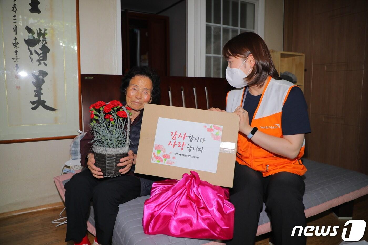 본문 이미지 - 6일 오전 광주 서구 광천동 한 가정에서 정다정 월드비전 무진종합사회복지관 과장이 혼자 살고 있는 문복순 할머니에게 어버이날 선물을 전달하고 있다. 2022.5.6/뉴스1 ⓒ News1 이승현 수습기자