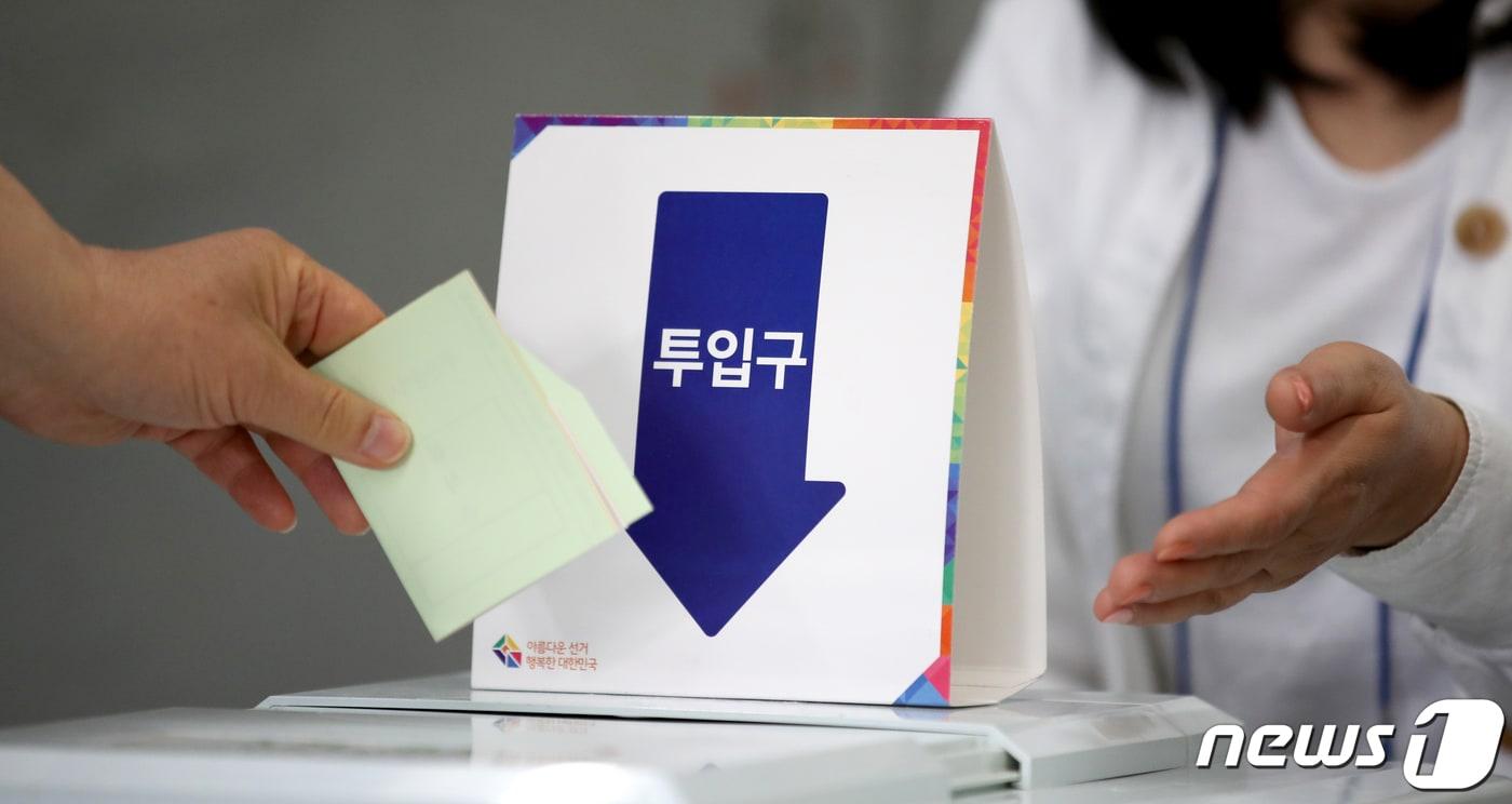 본문 이미지 - 제8회 전국동시지방선거일인 6월 1일 부산시 금정구 장전역에 마련된 투표소에서 유권자가 투표함에 투표지를 넣고 있다. 2022.6.1 ⓒ 뉴스1 김영훈 기자