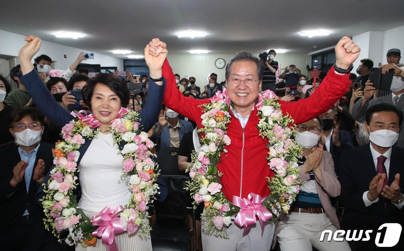 홍준표 국민의힘 대구시장 후보가 1일 오후 대구 중구 선거사무소에서 제8회 전국동시지방선거 개표 상황을 지켜보던 중 압도적인 차이로 당선이 유력해지자 꽃다발을 목에 걸고 부인 이순삼 여사와 함께 기뻐하고 있다. 2022.6.1/뉴스1 ⓒ News1 공정식 기자