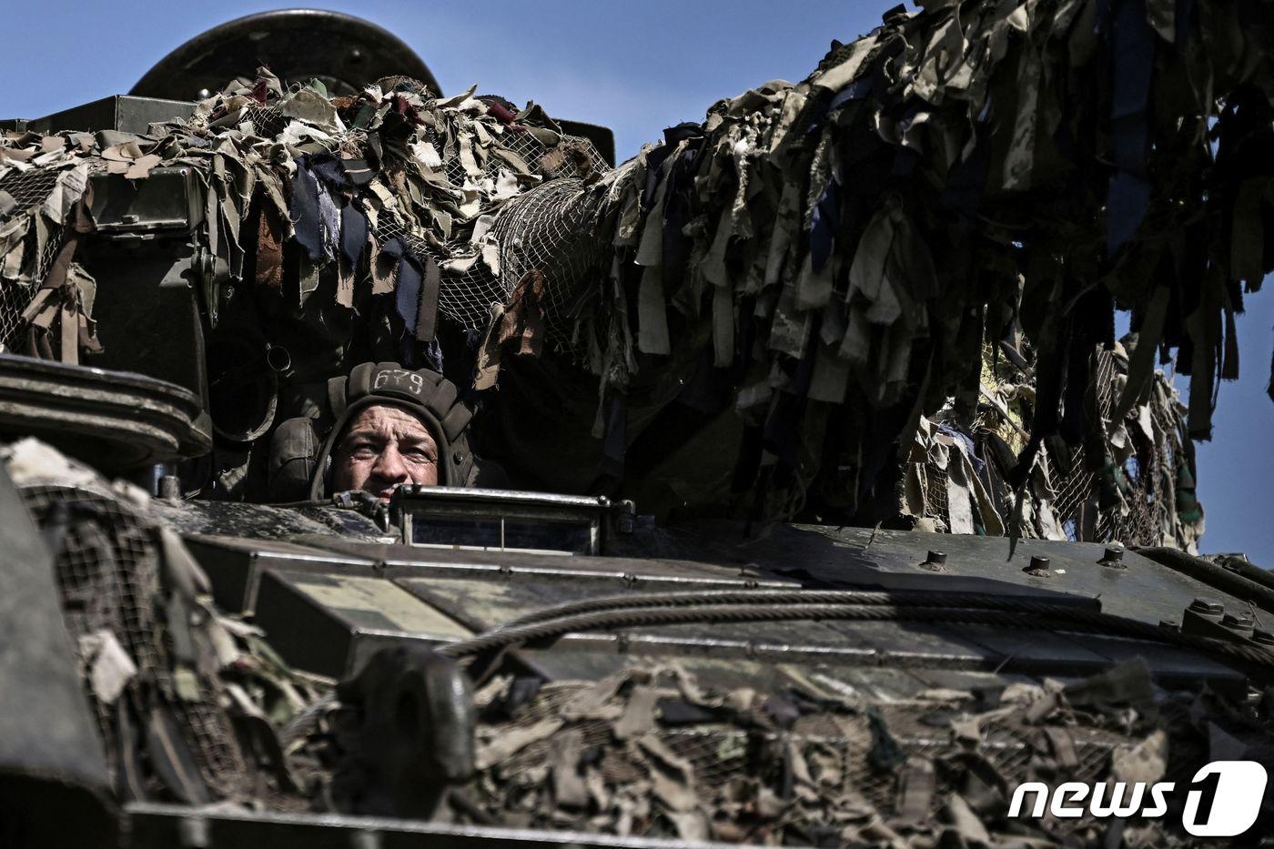 14일 (현지시간) 우크라이나 돈바스에서 러시아 군과 대치하고 있는 전선으로 병사가 주력 전차를 타고 이동하고 있다. ⓒ AFP=뉴스1 ⓒ News1 우동명 기자