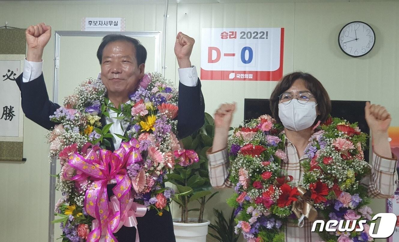 본문 이미지 - 거창군수 국민의힘 구인모 후보 부부가 당선이 확실시 되자 꽃다발을 목에 걸고 손을 번쩍 들어보이고 있다ⓒ 뉴스1