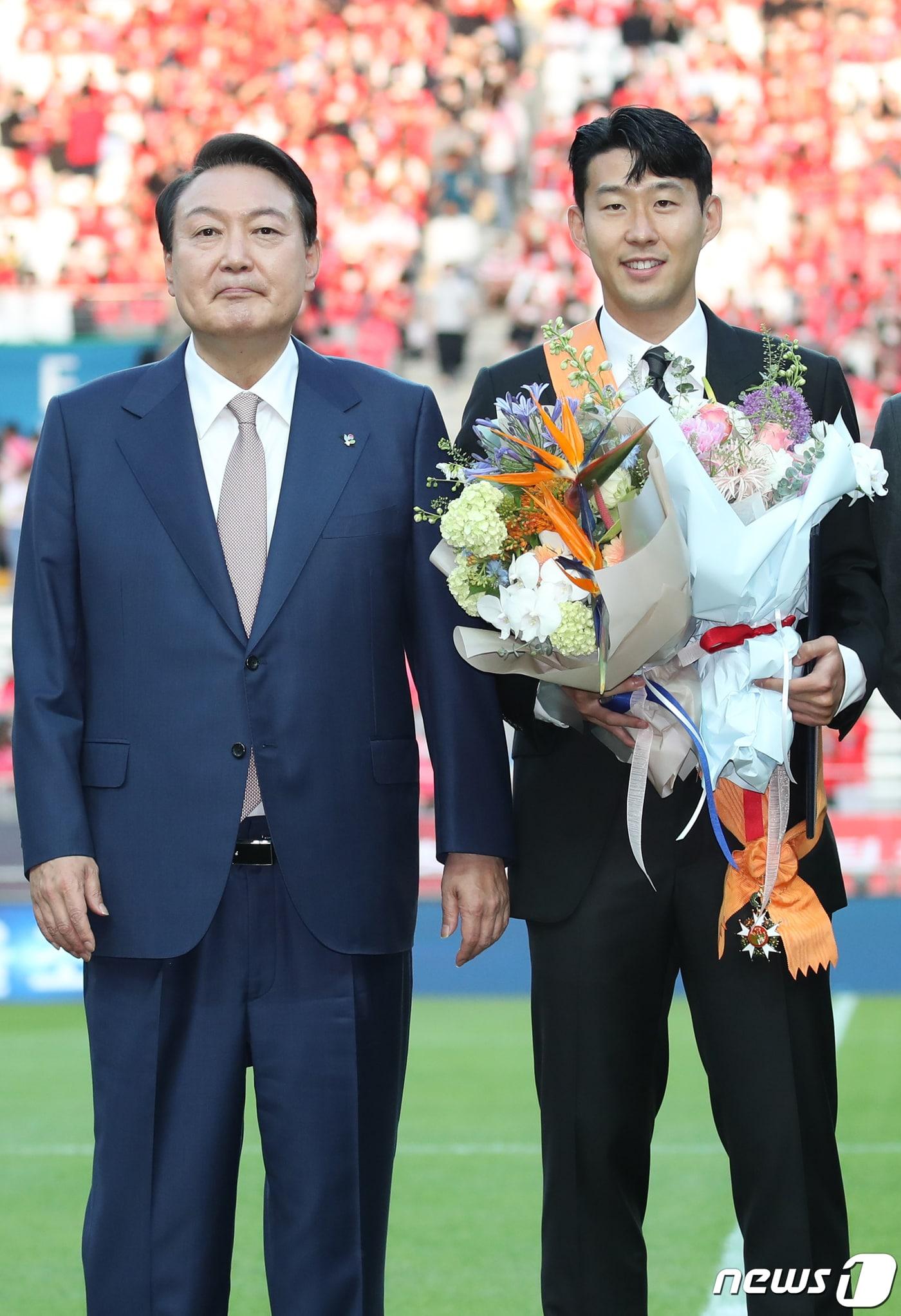 본문 이미지 - 윤석열 대통령이 2일 서울월드컵경기장에서 2002 한일월드컵 20주년 기념 평가전 대한민국-브라질의 경기에 앞서 잉글랜드 프로축구 프리미어리그(EPL)에서 아시아 선수 최초로 득점왕을 차지한 손흥민에게 체육훈장 최고등급인 청룡장을 수여한 뒤 기념촬영하고 있다. 대통령실사진기자단 2022.6.2/뉴스1 ⓒ News1 오대일 기자