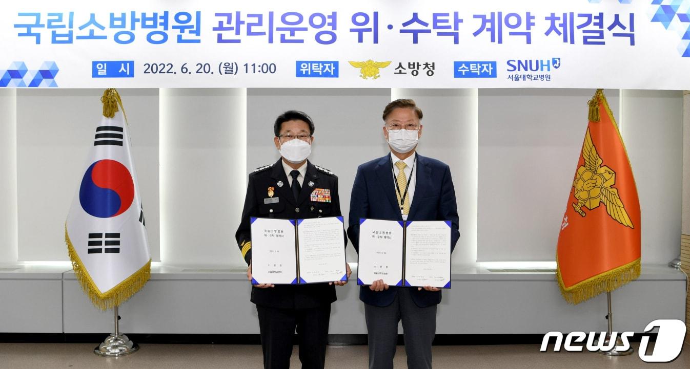 본문 이미지 - 2022년 6월 이흥교 당시 소방청장과 김연수 당시 서울대학교 병원장이 세종시 소방청에서 국립소방병원의 관리·운영을 위해 위·수탁 계약을 체결하고 있다. (소방청 제공) 