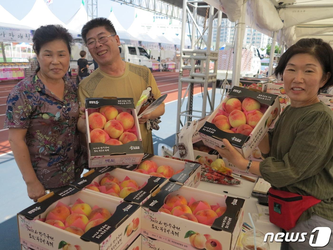 본문 이미지 - 2019년 향수 옥천 포도복숭아 축제 행사장에서 주민들이 농산물을 구입하는 모습.(옥천군 제공)ⓒ 뉴스1