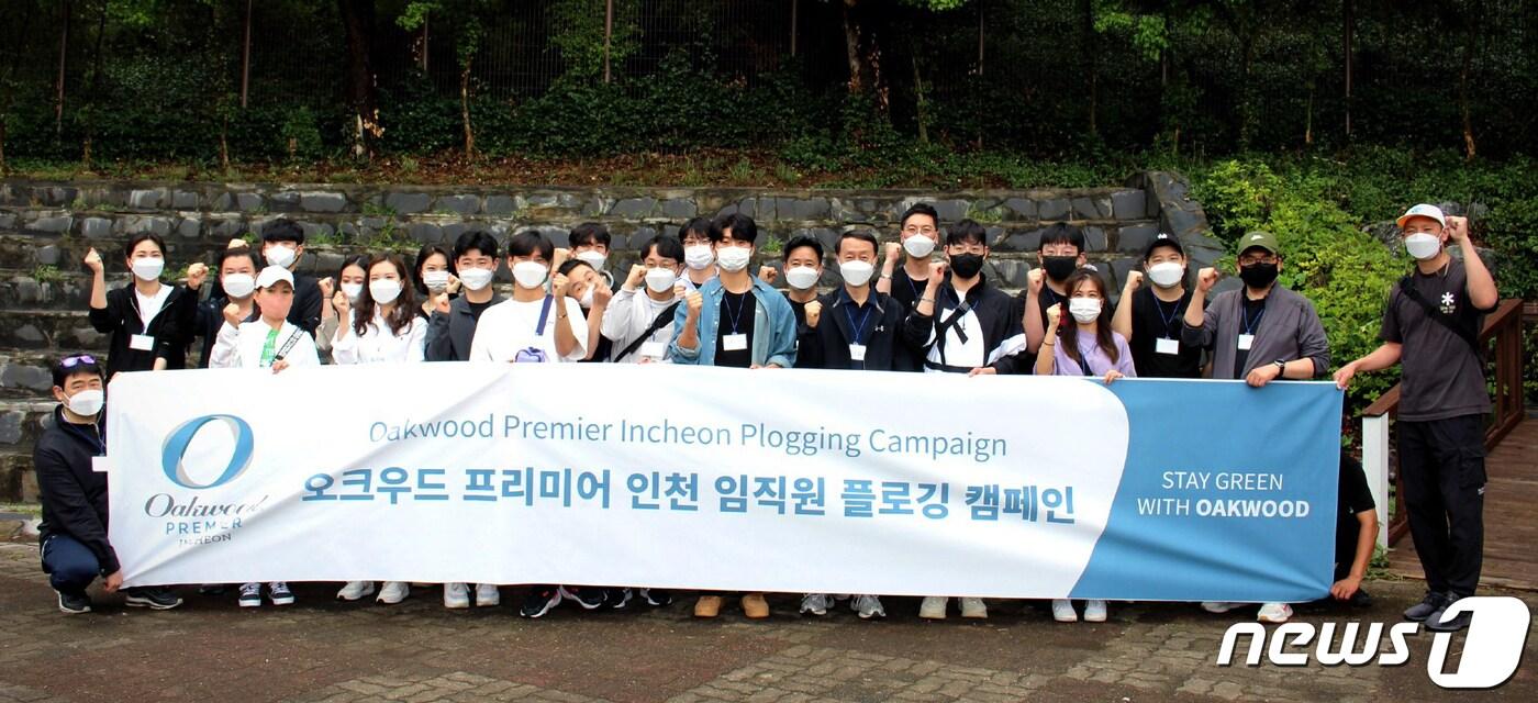 오크우드 프리미어 인천 관계자들이 인천대공원에서 플로킹 캠페인을 진행한 뒤 기념사진을 촬영하고 있다.(오크우드 프리미어 인천 제공)/ 뉴스1
