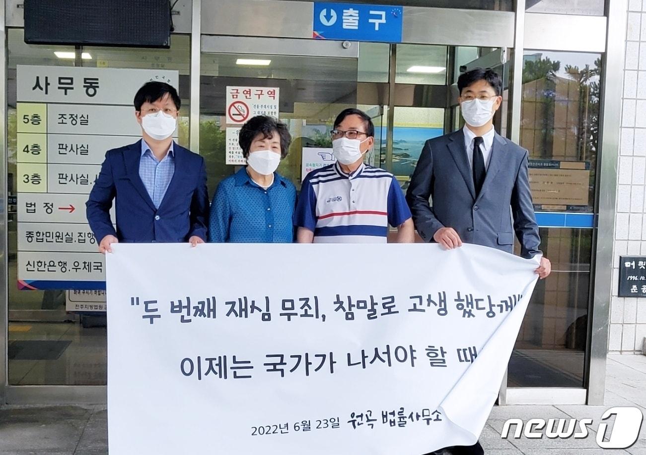 본문 이미지 - 반공법 사건 피해자 남정길씨(왼쪽에서 세 번째)가 군산지원에서 열린 재심선고 공판에서 무죄를 선고받고 부인 이선자씨와 변호사들과 함께 플래카드를 들고 서있다.2022.6.23./ⓒ 뉴스1
