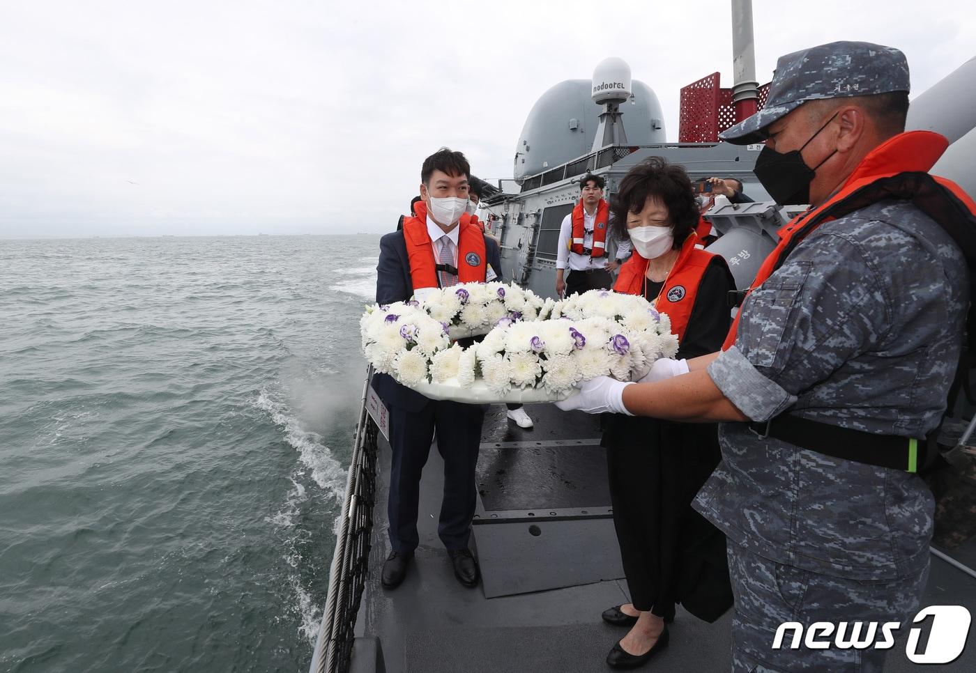 제2연평해전 승전 20주년 기념식이 열린 29일 오후 경기도 서해 해상에서 고(故) 윤영하 소령의 동생 윤영민 씨와 어머니 황덕희 씨가 유도탄고속함(PKG) '윤영하함'에서 해상 헌화를 하고 있다. 2022.6.29/뉴스1 ⓒ News1 김영운 기자