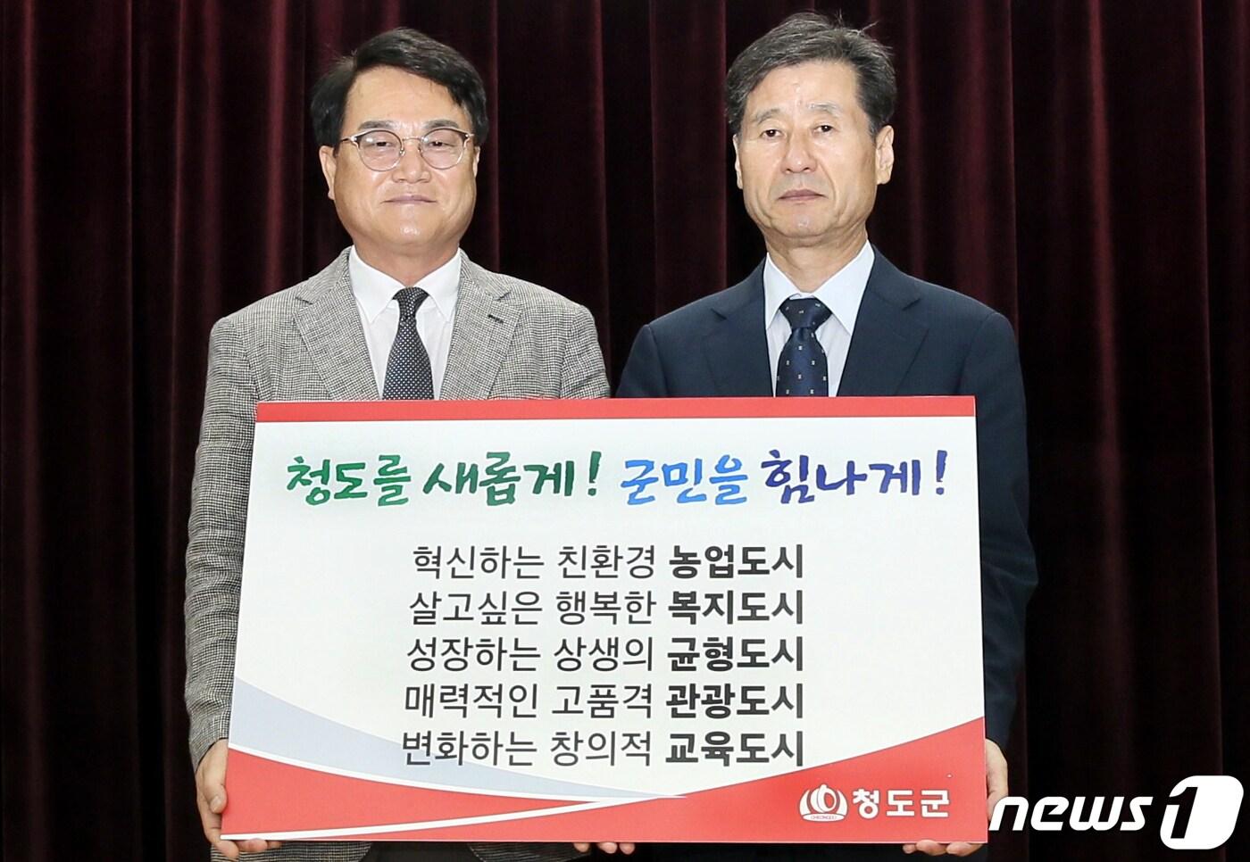 본문 이미지 - 김하수 청도군수(왼쪽)이 박진우 청도군수직 인수위원장으로부터 시정 슬로건과 5대 군정방침을 전달받고 있다. (청도군 제공)2022.6.30/ⓒ 뉴스1