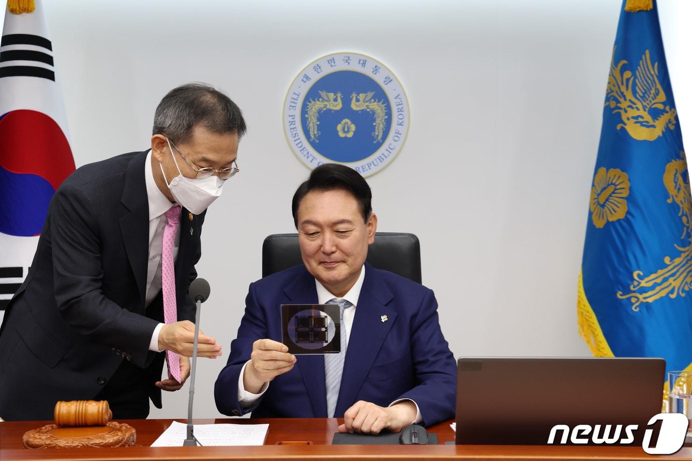 본문 이미지 - 윤석열 대통령이 7일 용산 대통령실 청사 영상회의실에서 열린 국무회의에서 반도체 포토마스크를 보고 있다. 왼쪽은 이종호 과학기술정보통신부 장관. (대통령실 제공) 2022.6.7/뉴스1 ⓒ News1 오대일 기자
