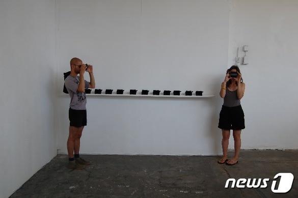 본문 이미지 - 전시장에서 뷰마스터로 사진을 보는 사람들. ⓒ 트레이시 임&#40;임은지&#41;