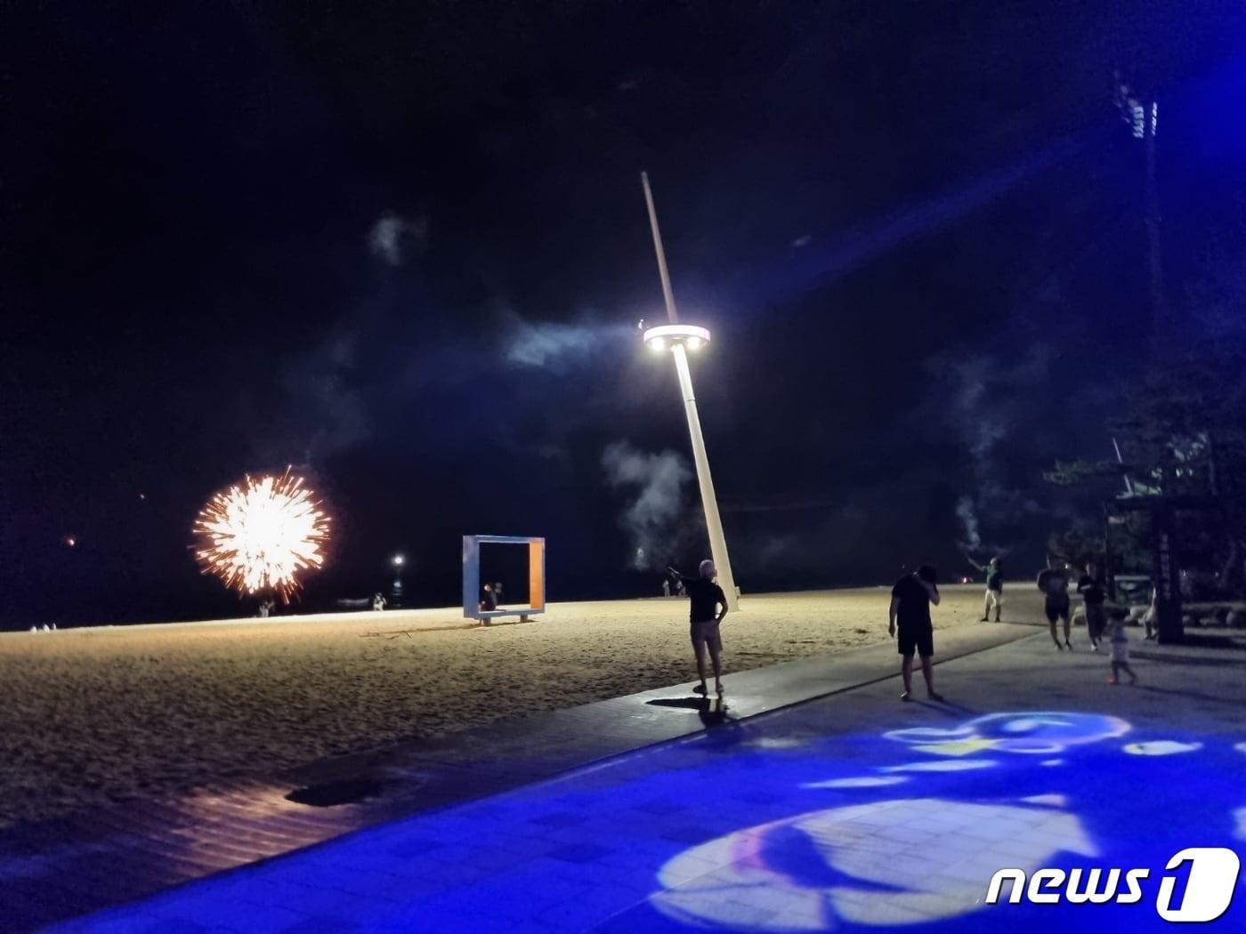 본문 이미지 - 무더위로 피서객이 몰린 지난달 30일 밤 미개장 경포해변 입구에서 한 남성이 폭죽을 백사장 한복판으로 쏘아대고 있다.2022.7.1/뉴스1 윤왕근 기자