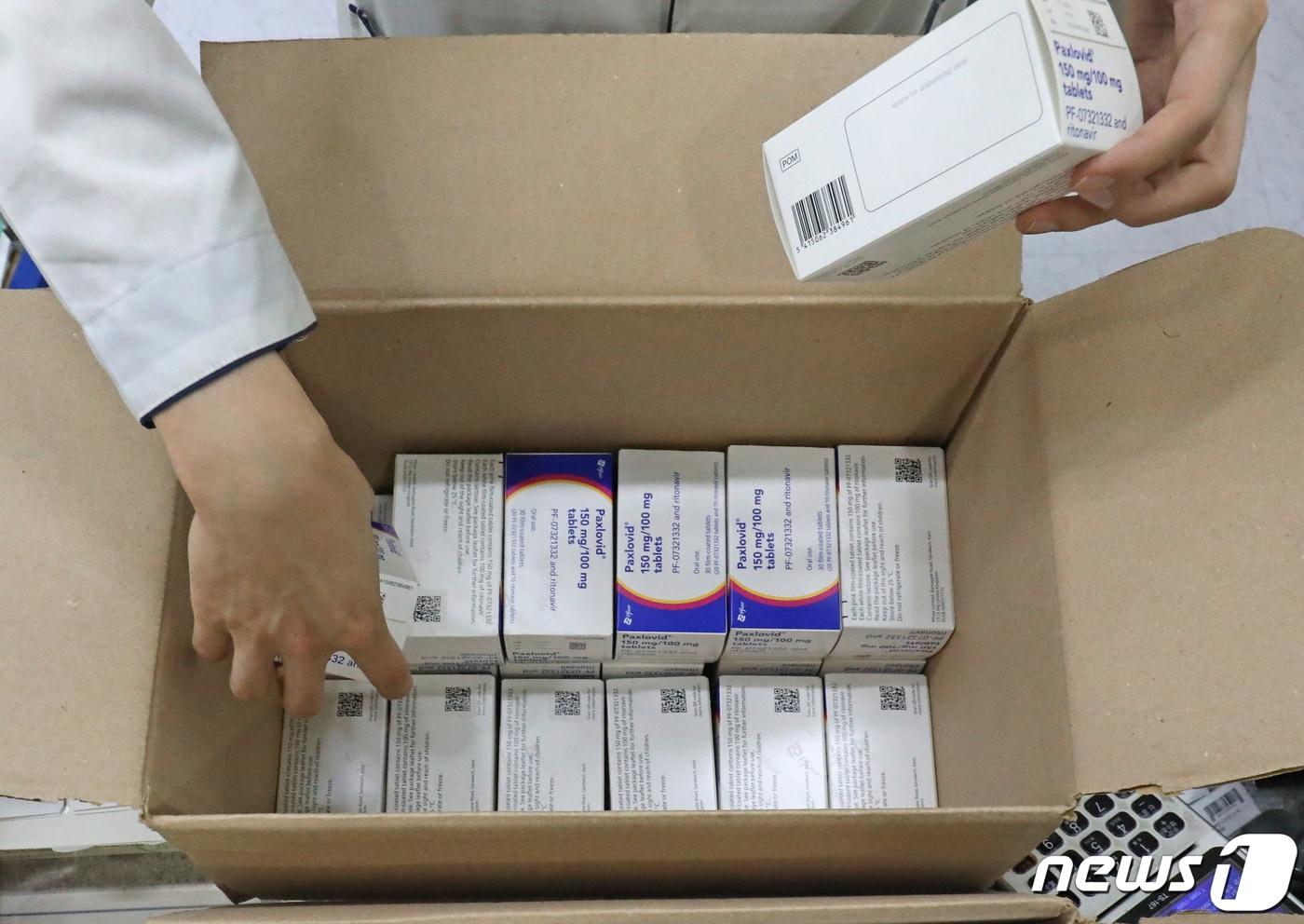 본문 이미지 - 서울의 한 약국에서 약사가 팍스로비드를 꺼내고 있다./뉴스1 ⓒ News1 이성철 기자