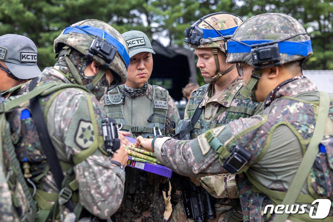 본문 이미지 - 지난 15~18일 강원도 인제 육군과학화전투훈련단(KCTC)에서  열린 'KCTC 여단급 쌍방훈련'에 참가한 한미 장병들이 작전토의를 하고 있다. (육군 제공) 2022.7.18/뉴스1