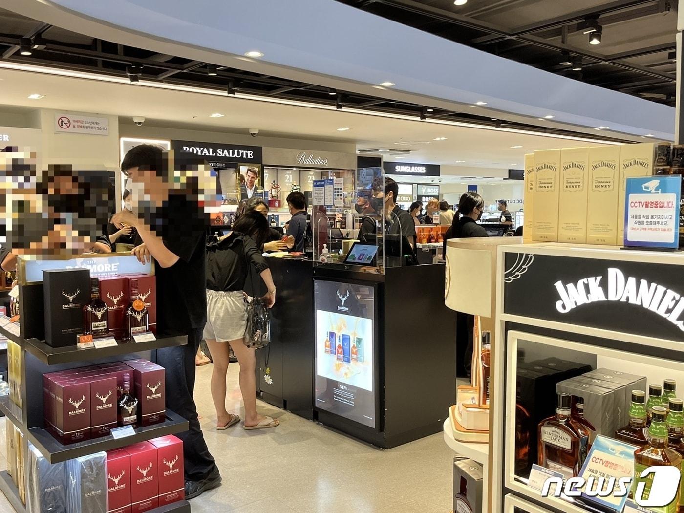 본문 이미지 - 17일 제주공항 면세점 주류 코너가 방문객들로 붐비는 모습.ⓒ 뉴스1 배지윤 기자