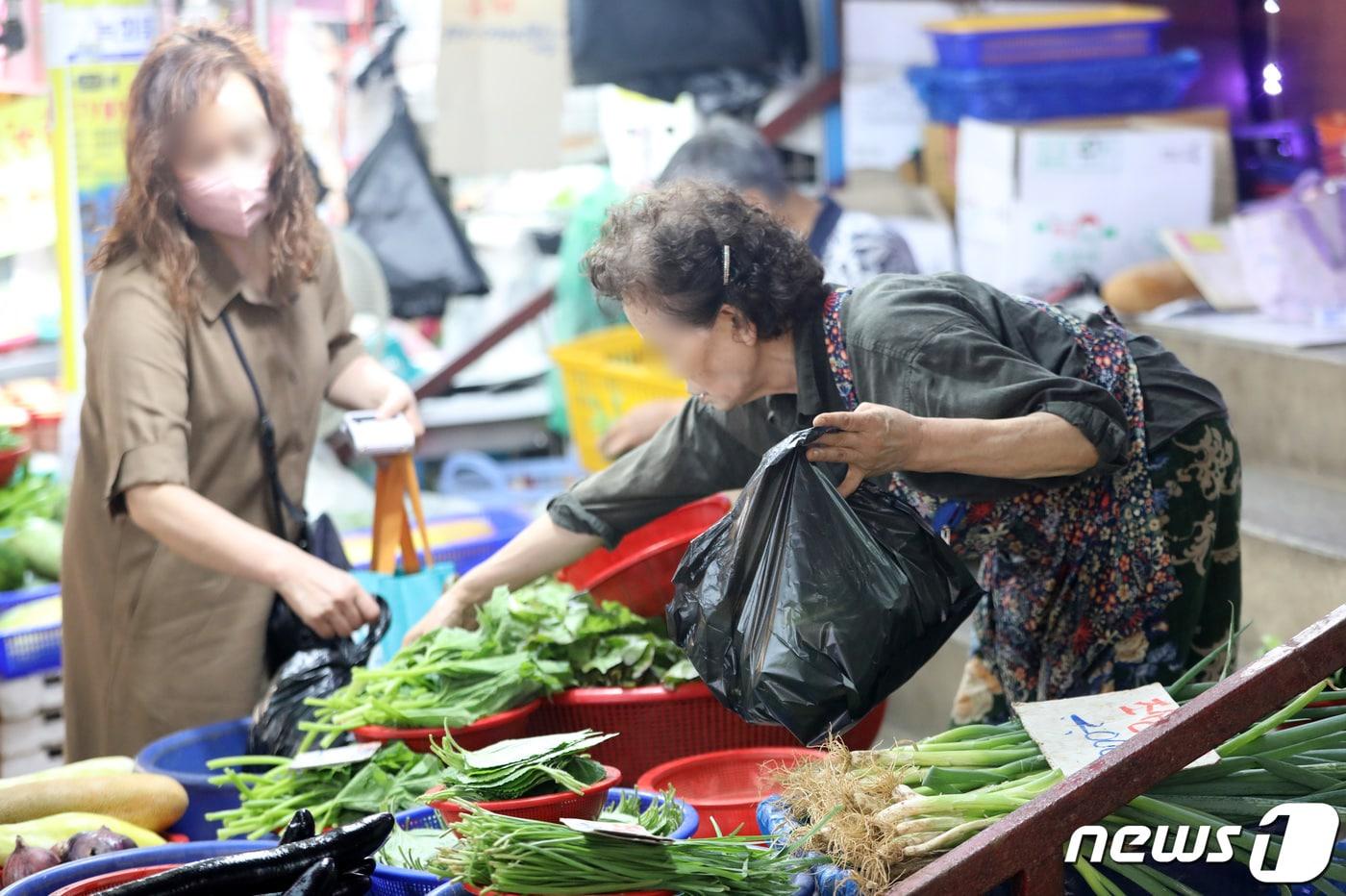 경기 수원 팔달구 못골종합시장의 한 채소 가게에서 시민들이 채소를 구매하고 있다. 2022.7.18/뉴스1 ⓒ News1 김영운 기자